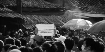apathetic-student-with-poster-middle-demonstration-saying-stop-struggle
