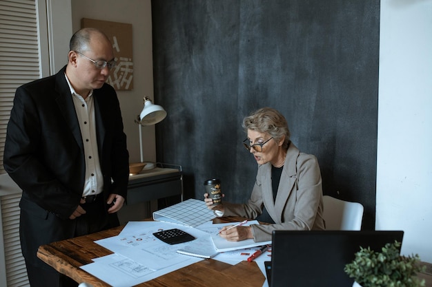 A lawyer sitting across from a client, reviewing estate planning documents. The scene is professional and focused, emphasizing the importance of legal and tax advice for estate planning