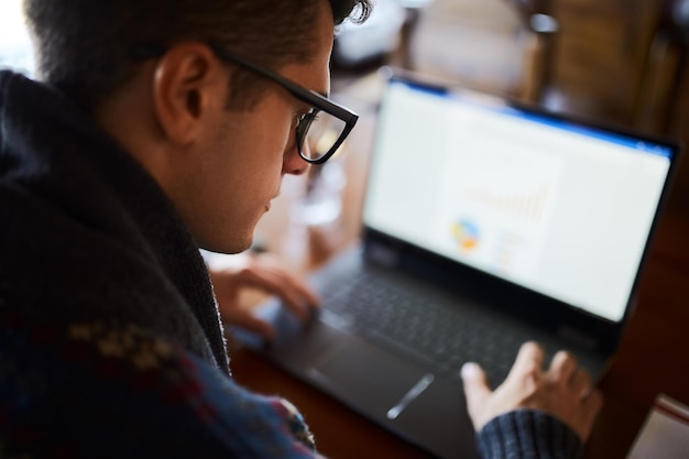 A close-up shot of a teacher using an AI-powered dashboard on a laptop in a classroom setting. The dashboard displays real-time student performance data, highlighting areas where students need additional support. The teacher is interacting with the data, seemingly adjusting lesson plans or identifying students for one-on-one assistance, illustrating AI's role in data-driven teaching adjustments.