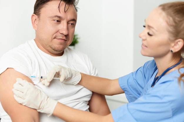 A person receiving an allergy shot in their arm, with a doctor administering the injection in a clinical setting.