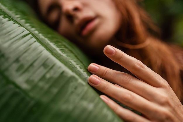 A close-up of a woman's hands gently applying a soothing moisturizer to her face, with a backdrop of natural light and calming green plants, promoting a sense of relaxation and self-care.