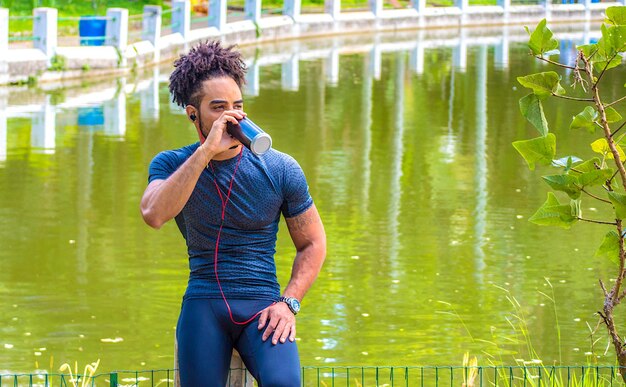 A person exercising outdoors, sweating while running in a park on a sunny day, highlighting the increased need for hydration during physical activity.