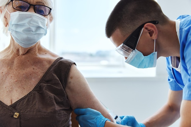 A close-up shot of a healthcare professional administering a flu shot to a patient's arm, with focus on the needle insertion point. The background is blurred, creating a sense of clinical precision and care.