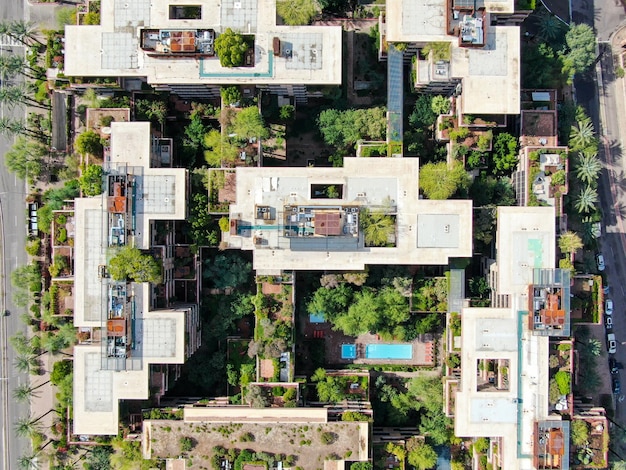 An aerial view of a modern co-living building in a bustling urban environment. The building's design incorporates communal spaces and private balconies, blending privacy with community interaction.