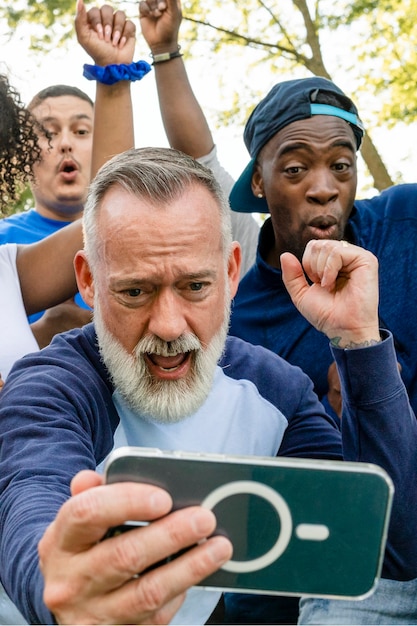 A group of diverse people holding signs and protesting peacefully. Some are using their smartphones to livestream the event and share updates on social media.