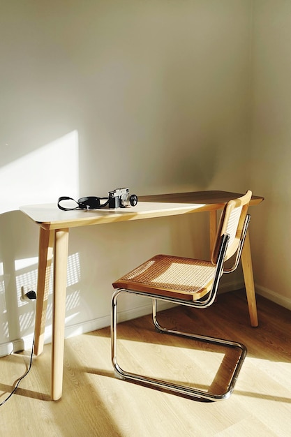 A minimalist home office with a custom-built desk made of reclaimed wood, ergonomic chair, and a large window overlooking a peaceful garden. The room is decorated with personal items, books, and a few potted plants.