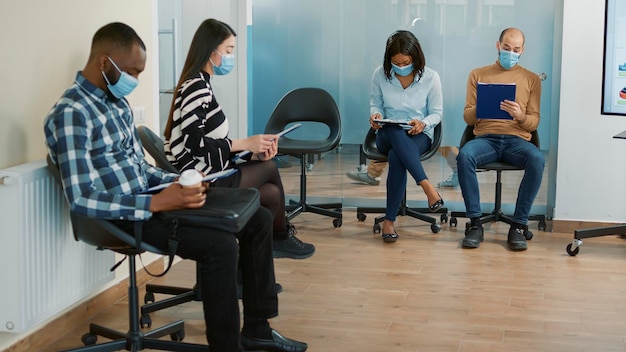 A diverse group of people in a medical clinic waiting room, representing the broad demographic affected by healthcare regulations.