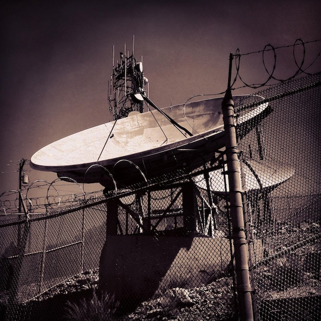 A close-up of a FEMA mobile command center set up in a disaster-stricken area. The image focuses on the satellite communication dishes and the activity of personnel inside.