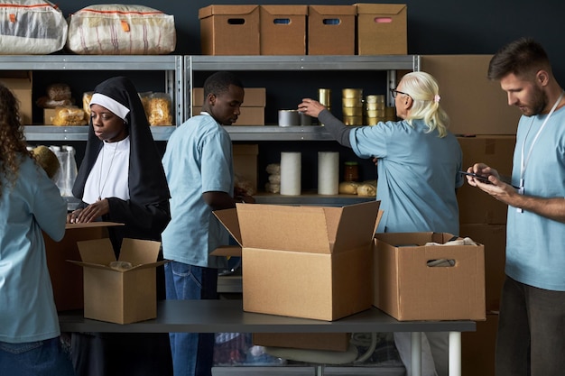 A group of volunteers unloading boxes of supplies from a truck at a FEMA distribution center. The scene shows a coordinated effort to get resources to those in need.
