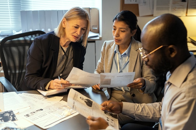 A diverse group of people looking at financial charts and tax documents in a modern office setting.